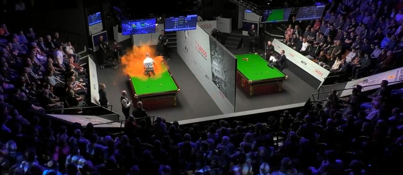 Scene halucinante la Campionatul Mondial de snooker! Așa ceva nu s-a mai întâmplat! Un protestatar s-a urcat pe masă în timpul meciului și a distrus-o după ce a împrăștiat un praf portocaliu! La masa alăturată s-a încercat același gest extrem! VIDEO