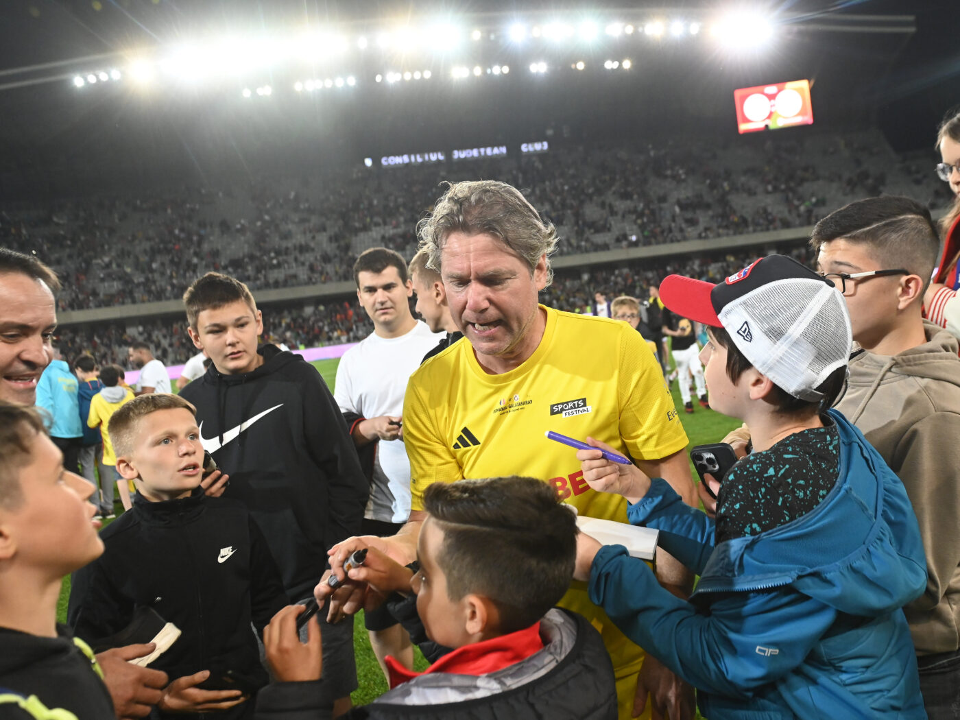 „Minunea Blondă” a rămas neschimbat: Florin Răducioiu, magnet pentru copii la meciul Romania All Stars – Galatasaray Legends! Fostul atacant al lui AC Milan a dat autografe direct pe teren | FOTO